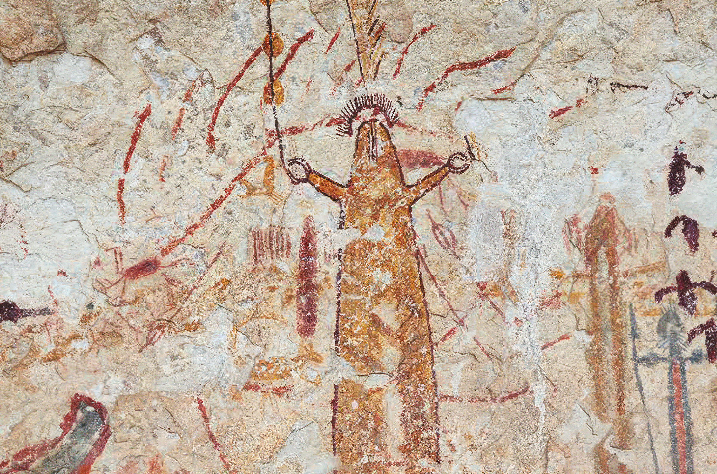 Between claw-like fingers this yellow and red anthropomorph at Halo Shelter raises an enigmatic object in its right hand