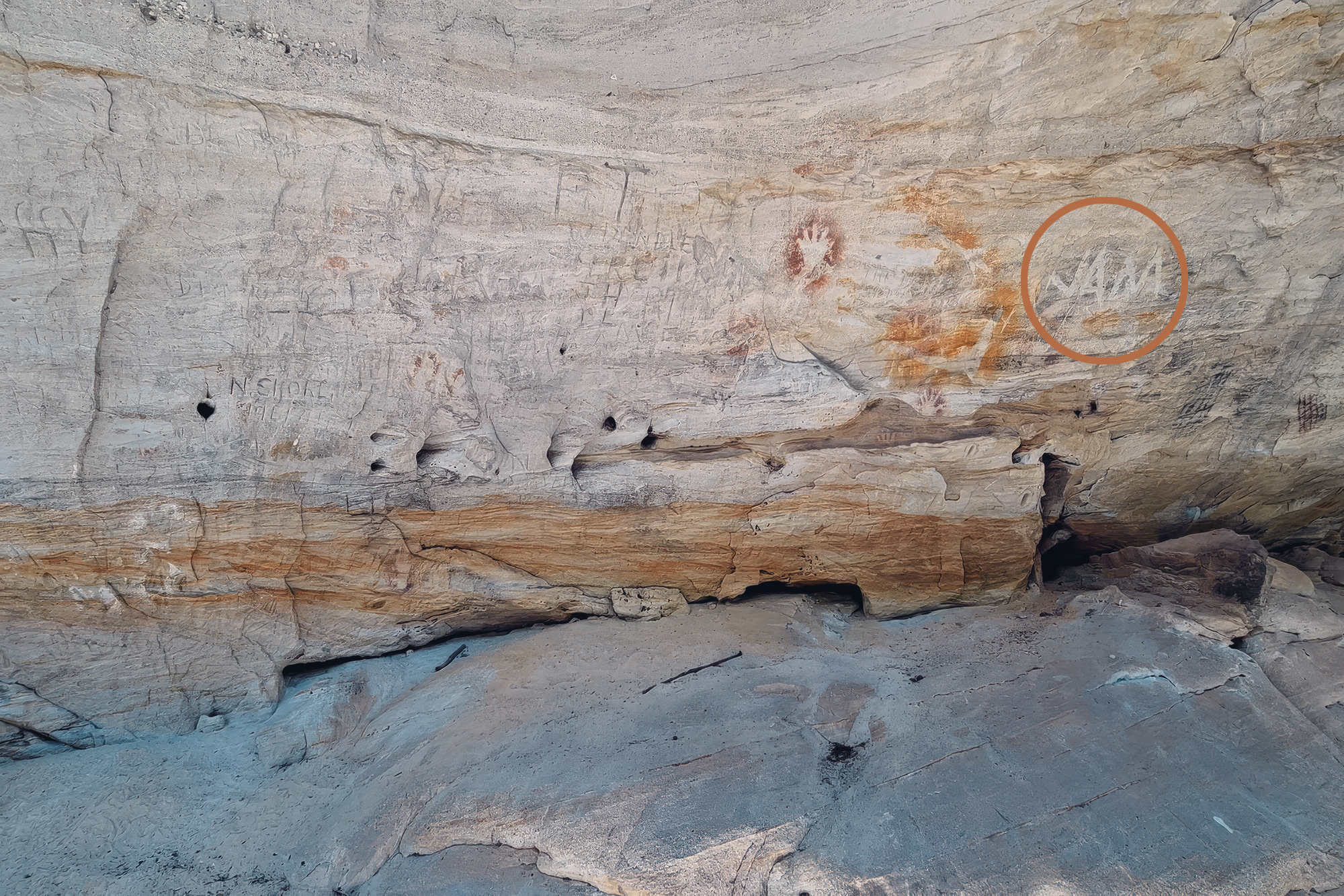 People visiting a sacred site in Queensland have been carving and spraying their names on ancient rock art
