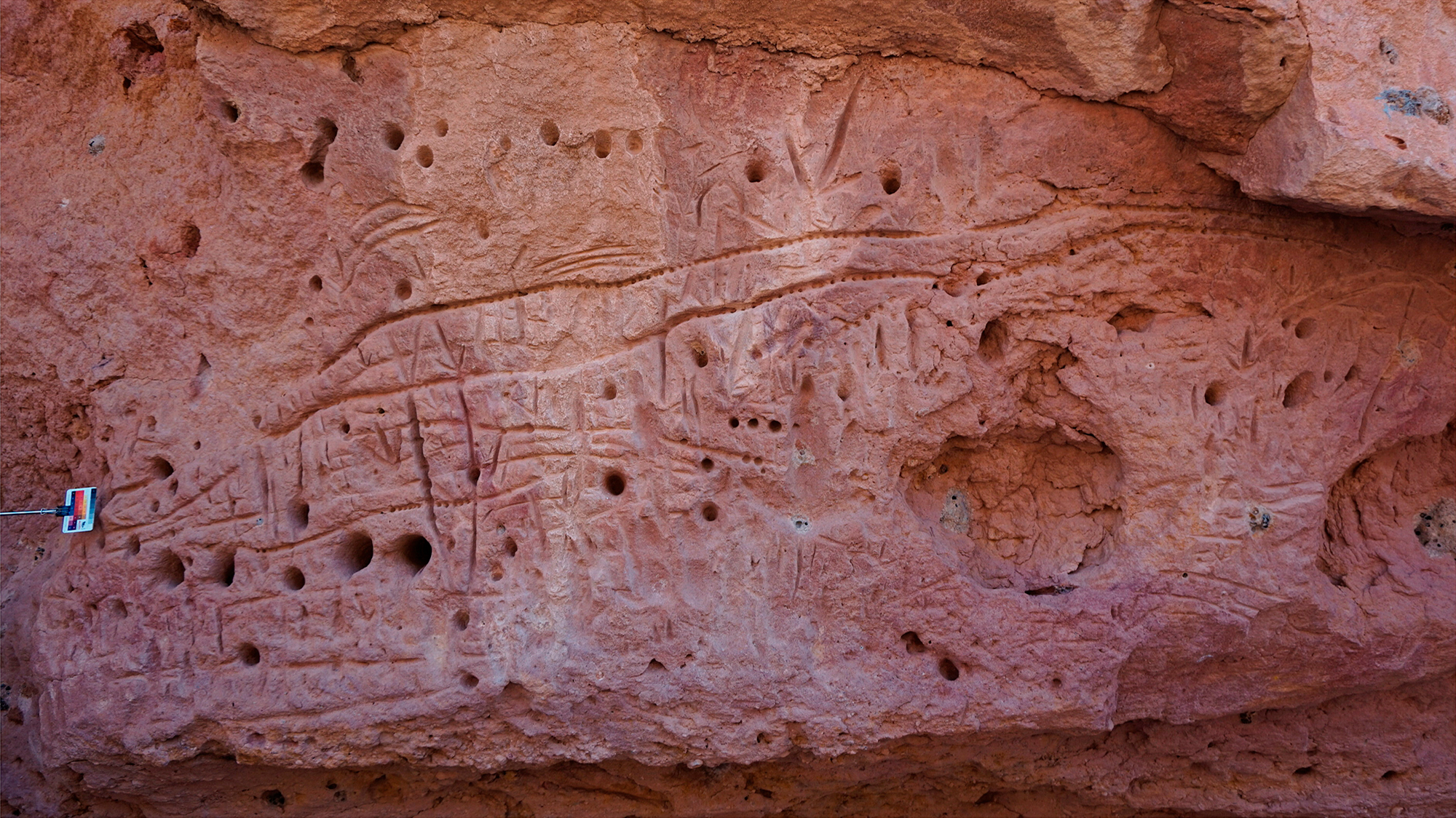 Engraved snake-like design on the wall between the anthropomorph and the cluster of engraved feet